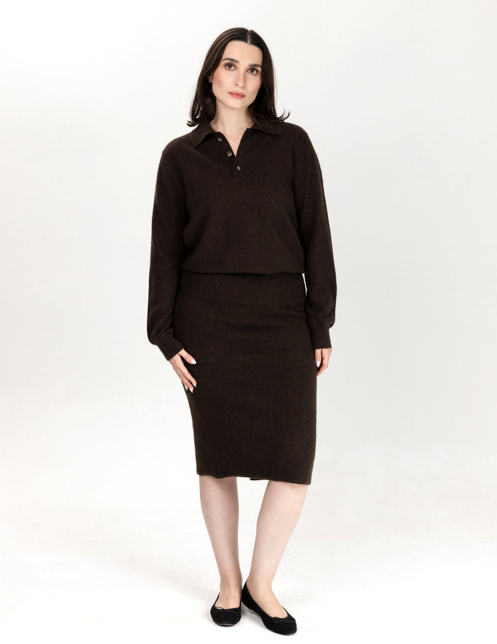 A woman modeling a dark brown knit two-piece set consisting of a long-sleeve collared top and a matching knee-length skirt, paired with black flats, against a plain white studio background - Natural Brown