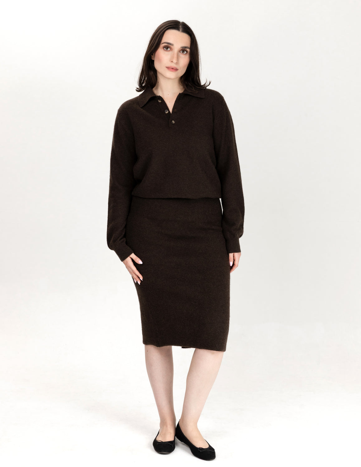 A woman modeling a dark brown knit two-piece set consisting of a long-sleeve collared top and a matching knee-length skirt, paired with black flats, against a plain white studio background - Natural Brown