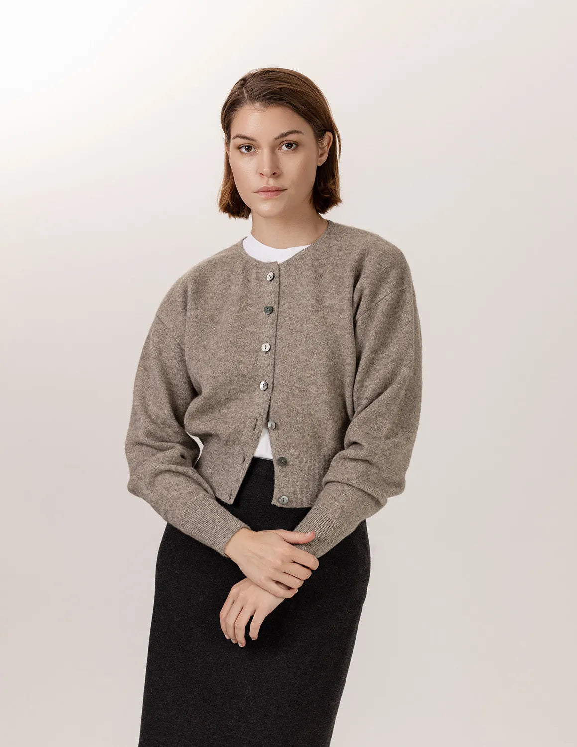 Woman wearing a gray cardigan over a white shirt on a plain background - Natural Grey