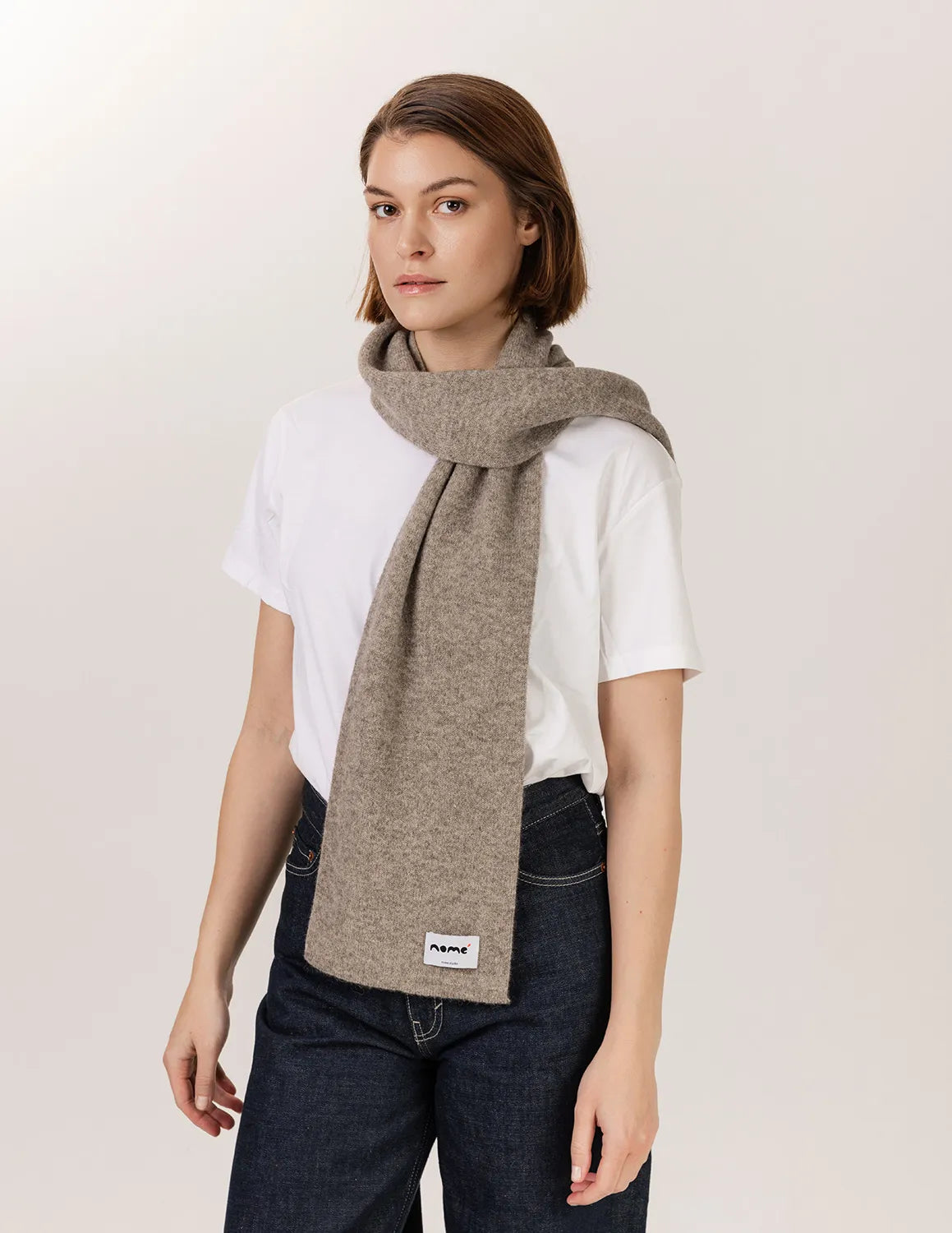 Woman wearing a beige scarf with a visible brand label on a plain background - Natural Grey
