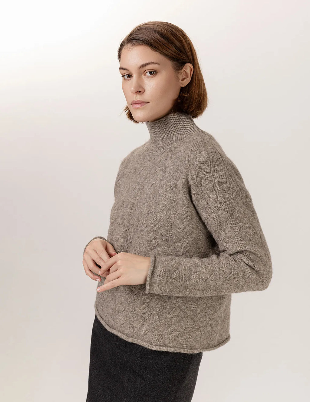 Woman wearing a beige turtleneck sweater against a white background - Natural Grey