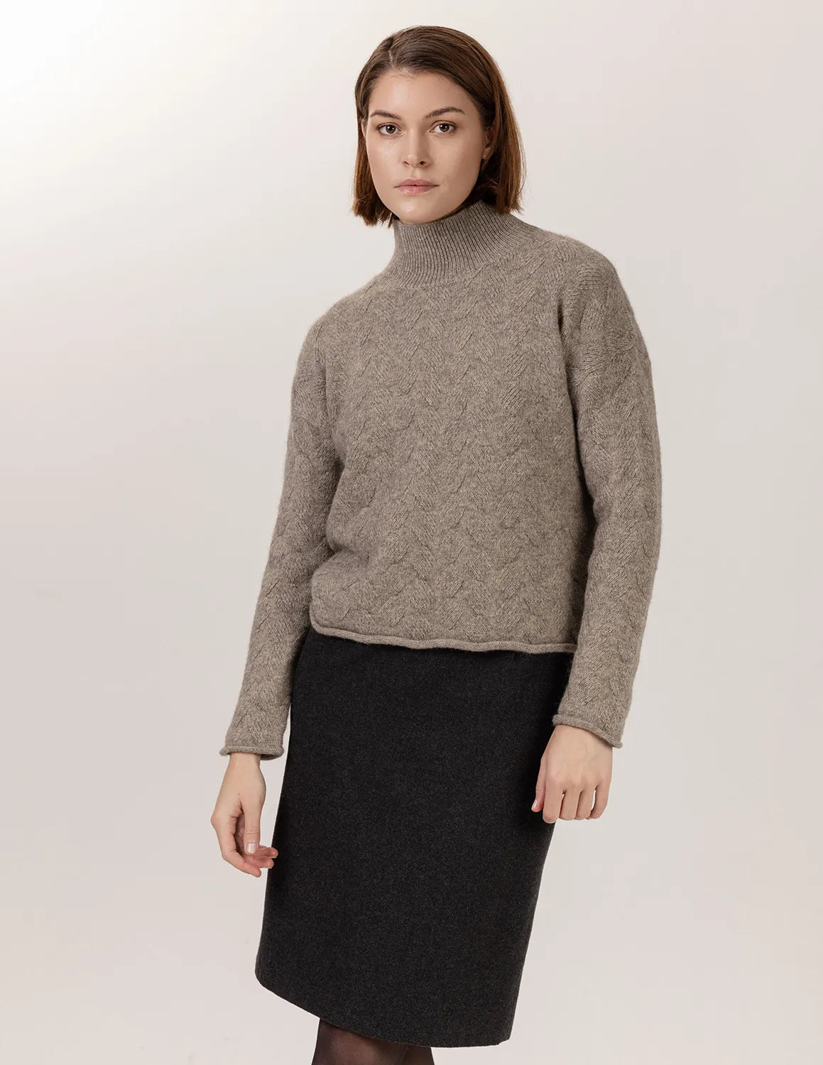 Woman wearing a gray turtleneck sweater and black skirt on a white background - Natural Grey