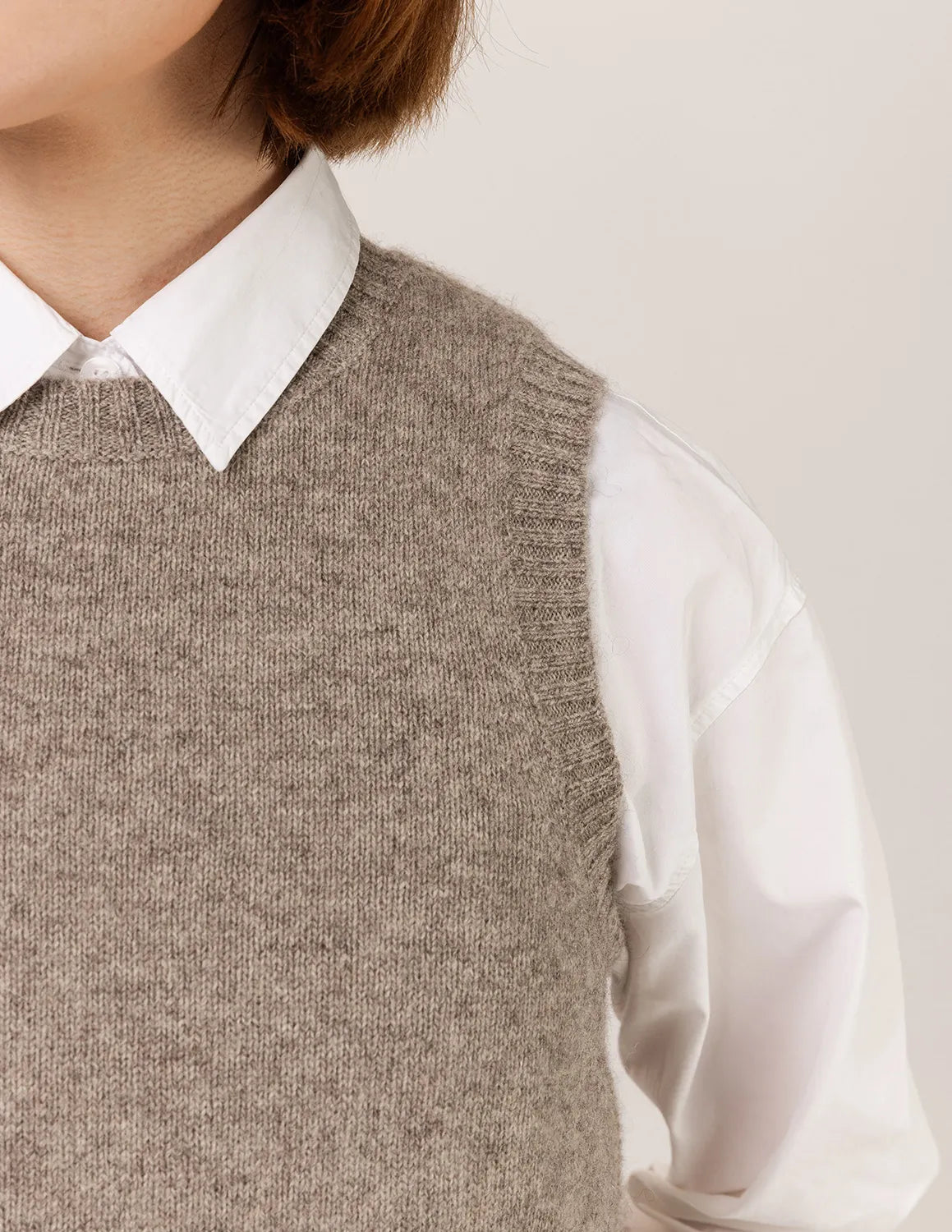 Person wearing a brown knitted vest over a white shirt on a plain background - Natural Grey