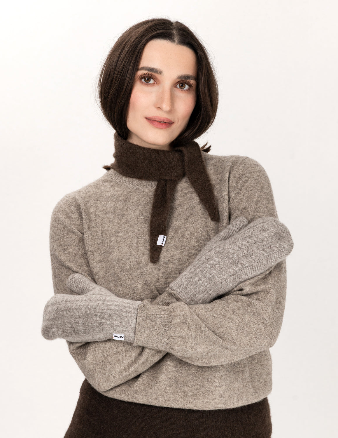 A woman wearing Nomé Teshig mittens along with other Nomé garments - Natural Grey
