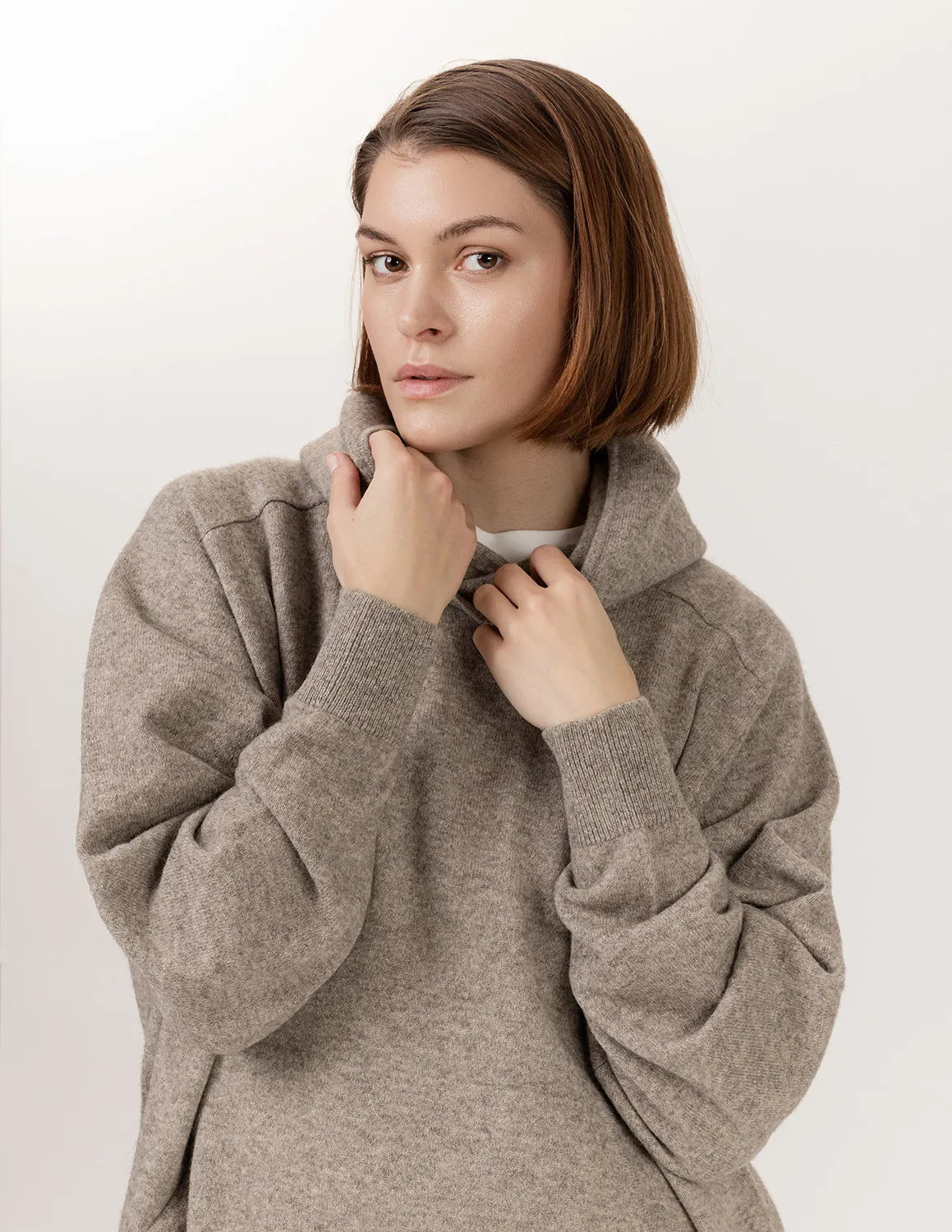 Woman wearing a beige sweater against a white background - Natural Grey