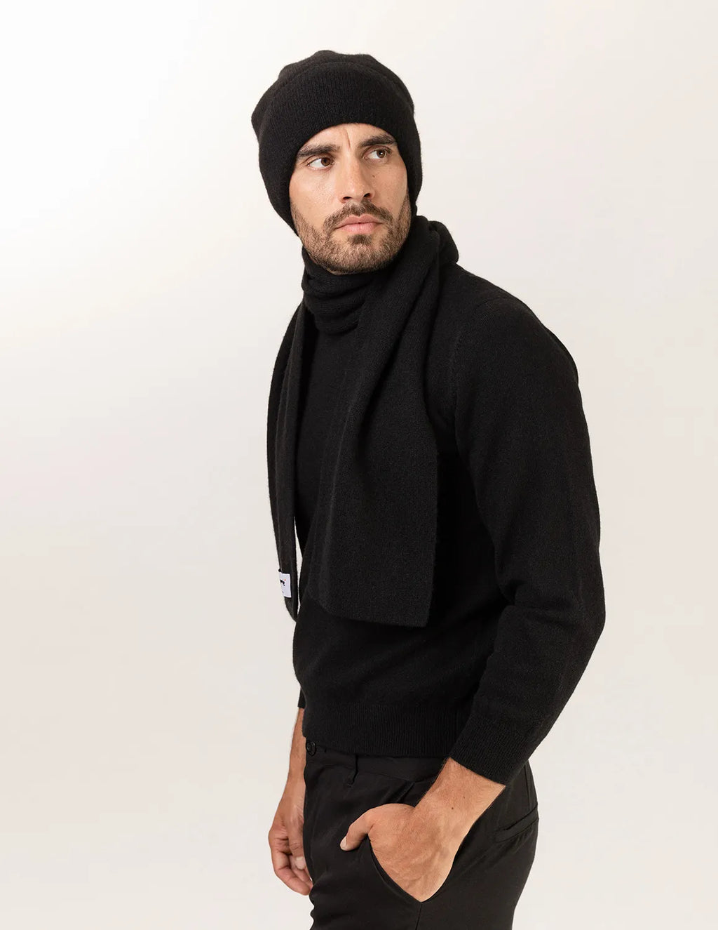 Man wearing a black knit beanie and scarf on a white background - Black