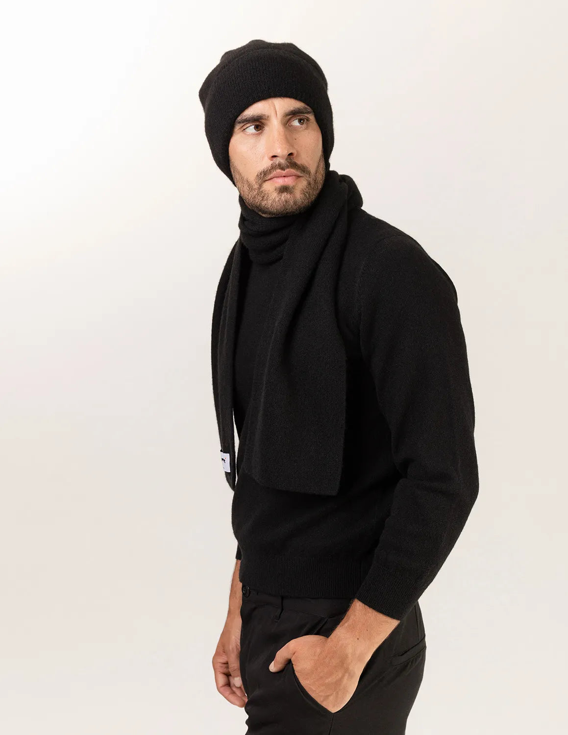 Man wearing a black knit beanie and scarf on a white background - Black