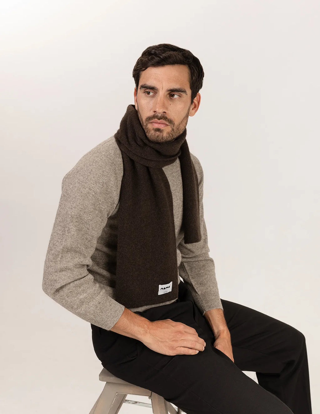 Man wearing a brown scarf and gray sweater sitting on a stool against a white background - Natural Brown